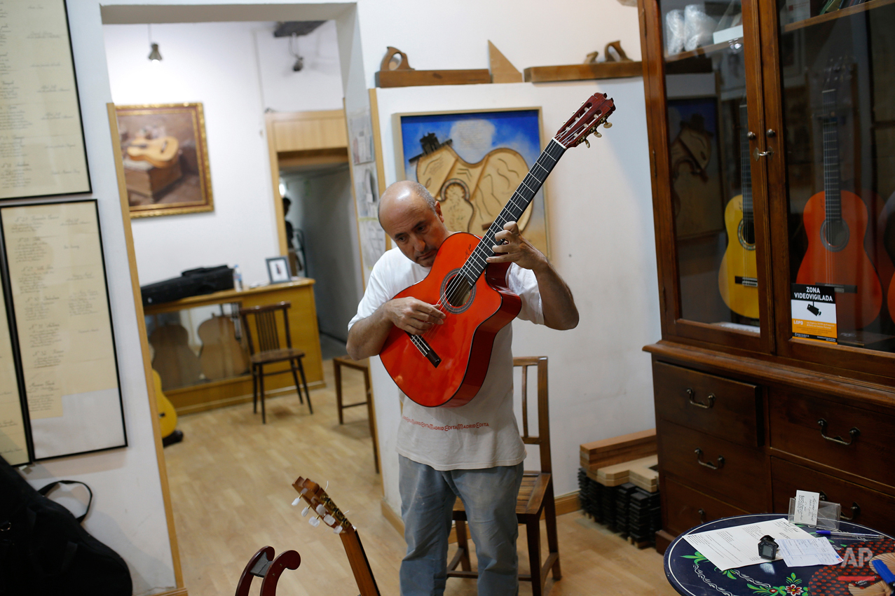  In this Wednesday, Nov. 11, 2015 photo, Spanish guitar maker Mariano Conde tunes a guitar at his workshop in Madrid. Carrying on the family tradition is Mariano Conde, who operates out of his workshop in downtown Madrid where and he and his son, als