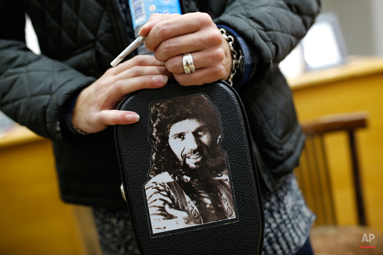  In this Wednesday, Nov. 11, 2015 photo, Spanish 'flamenco' artist Yoni Jimenez rests his hands on his guitar case decorated with a photo of 'flamenco' icon singer "Camaron de la Isla" at a guitar workshop in Madrid. Spanish flamenco guitars are know