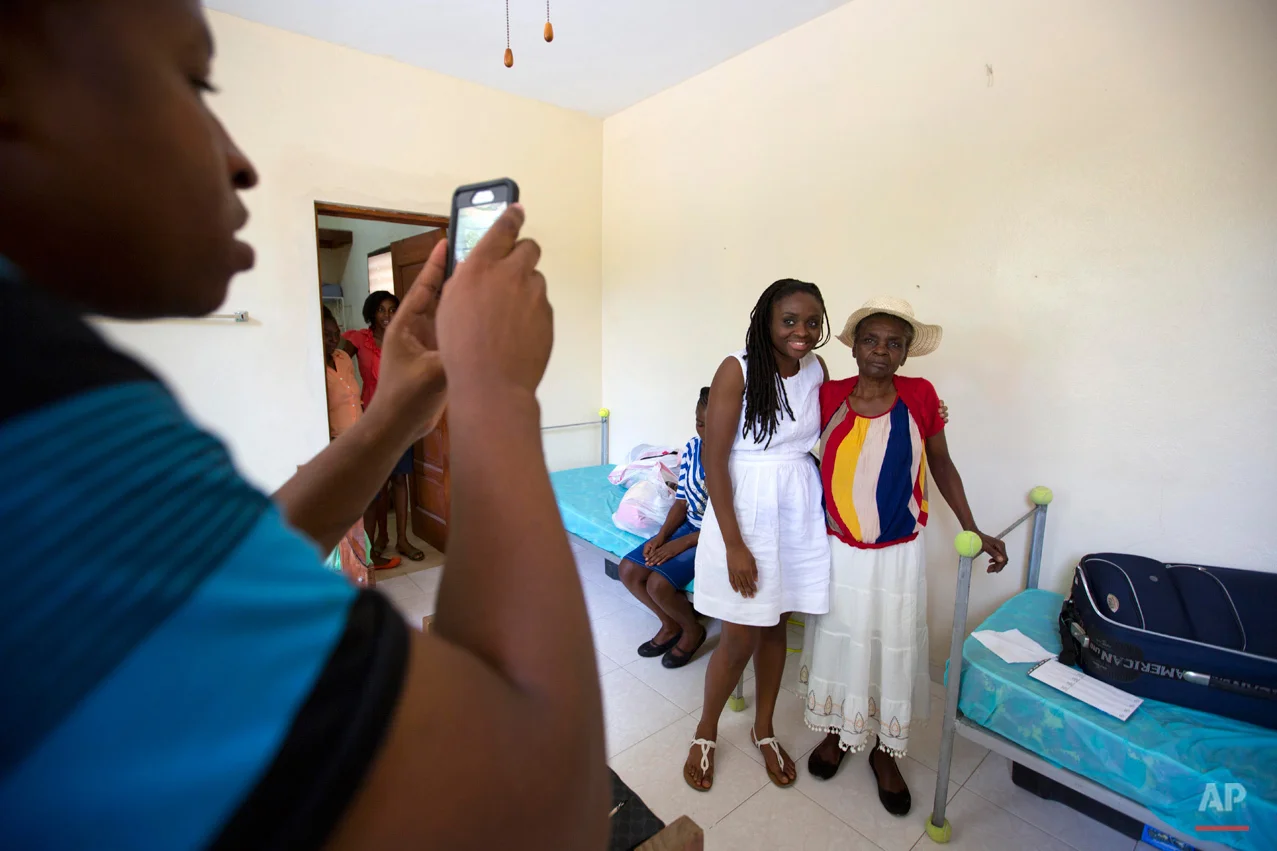  In this July 13, 2015 photo, Mariette Williams poses for a photo with her birth mother Colas Etienne, in Port-au-Prince, Haiti. Colas was a shadow at the very edge of Mariette's memories, a daughter who had been adopted by a Canadian couple in 1986.