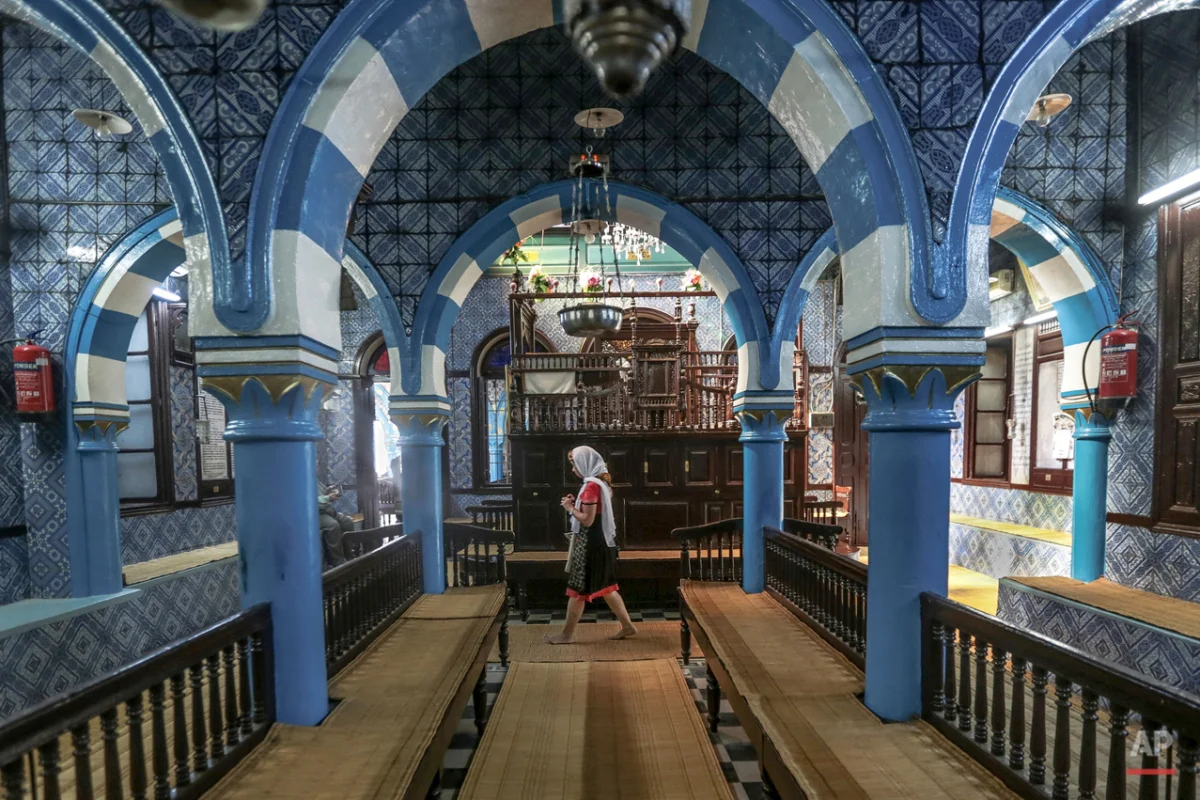  In this Wednesday, Oct. 28, 2015 photo, a tourist visits La Ghriba, the oldest synagogue in Africa, on the Island of Djerba, southern Tunisia. Beneath intricate tile walls bearing blue and yellow geometric shapes that would not seem out of place at 