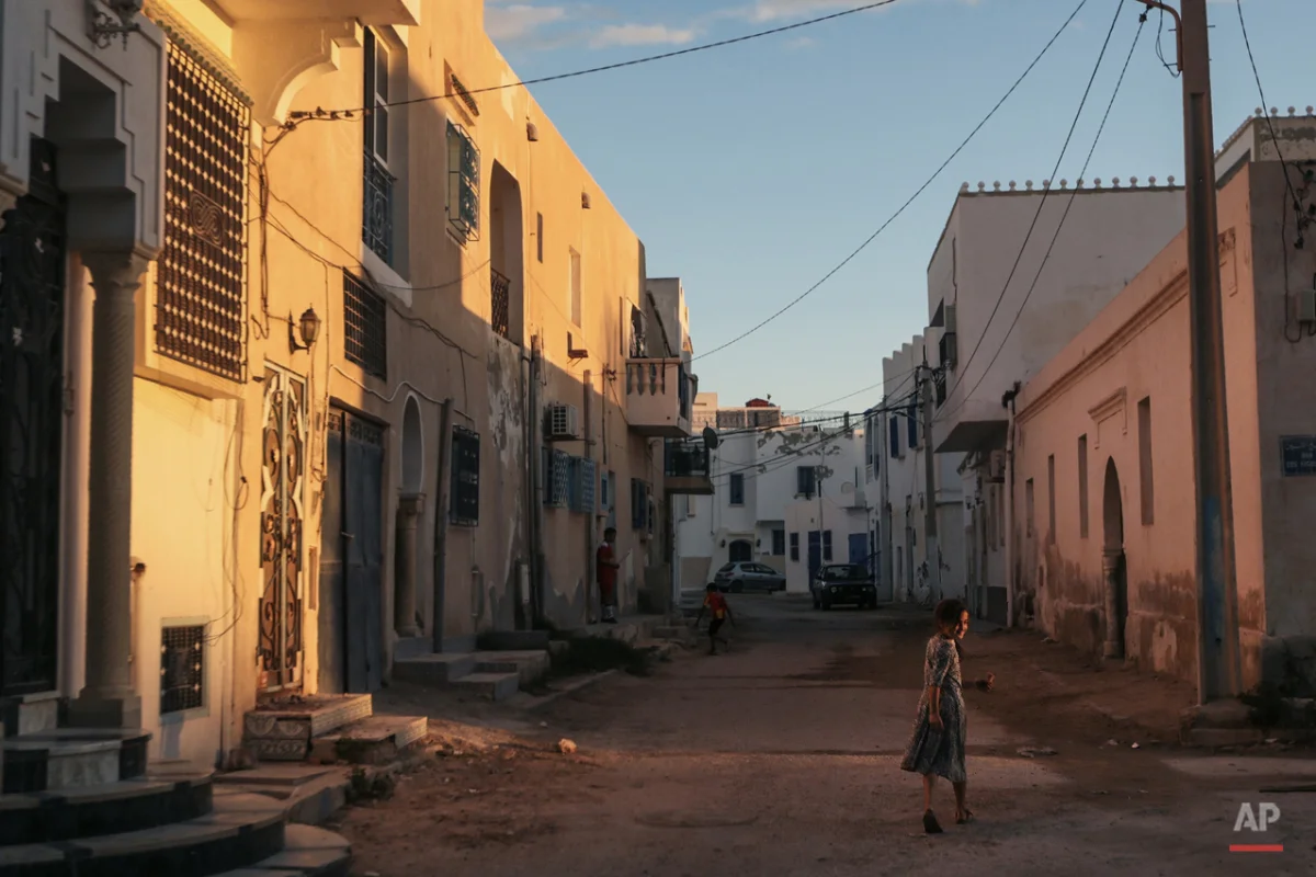  In this Friday, Oct. 30, 2015 photo, a girl walks home after sunset, at Hara Kbira, the main Jewish neighborhood on the Island of Djerba, southern Tunisia. The Jewish community in the resort island of Djerba traces its roots all the way back to Baby