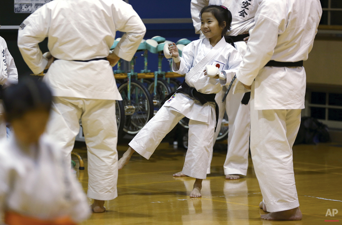  In this Nov. 18, 2015 photo, 9-year-old Mahiro Takano, center, three-time Japan karate champion in her age group chat with her karate instructors during practice in Nagaoka, Niigata Prefecture, north of Tokyo. Mahiro stars in singer Sia’s latest mus
