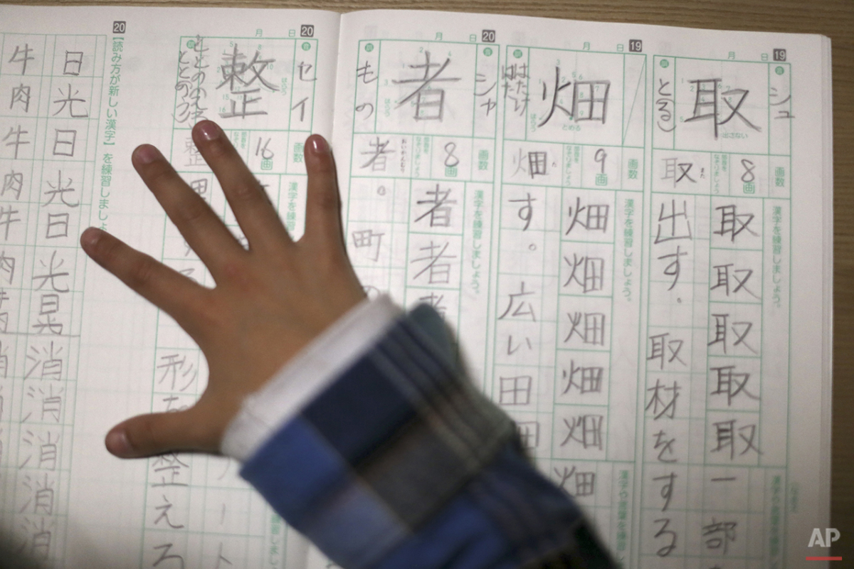  In this Nov. 18, 2015 photo, 9-year-old Mahiro Takano, three-time Japan karate champion in her age group does her homework of Japanese letters Kanji before going to her practice of karate at home in Nagaoka, Niigata Prefecture, north of Tokyo. Mahir