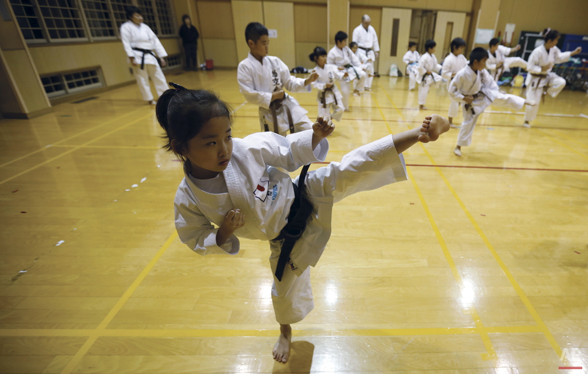  In this Nov. 18, 2015 photo, 9-year-old Mahiro Takano, center, three-time Japan karate champion in her age group practices in Nagaoka, Niigata Prefecture, north of Tokyo.  Mahiro stars in singer Sia’s latest music video “Alive,” the just-released si