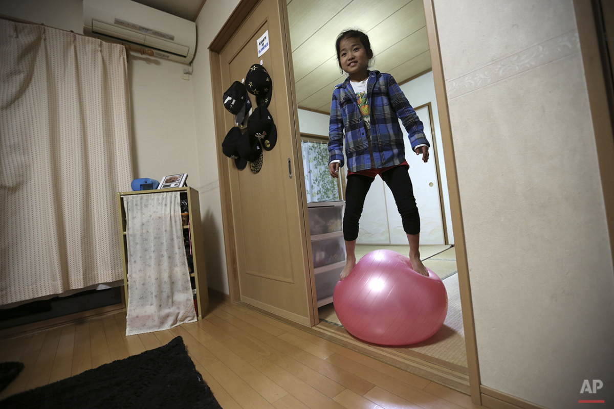  In this Nov. 18, 2015 photo, 9-year-old Mahiro Takano, three-time Japan karate champion in her age group plays with a balance ball before going to her practice of karate at home in Nagaoka, Niigata Prefecture, north of Tokyo. Mahiro stars in singer 