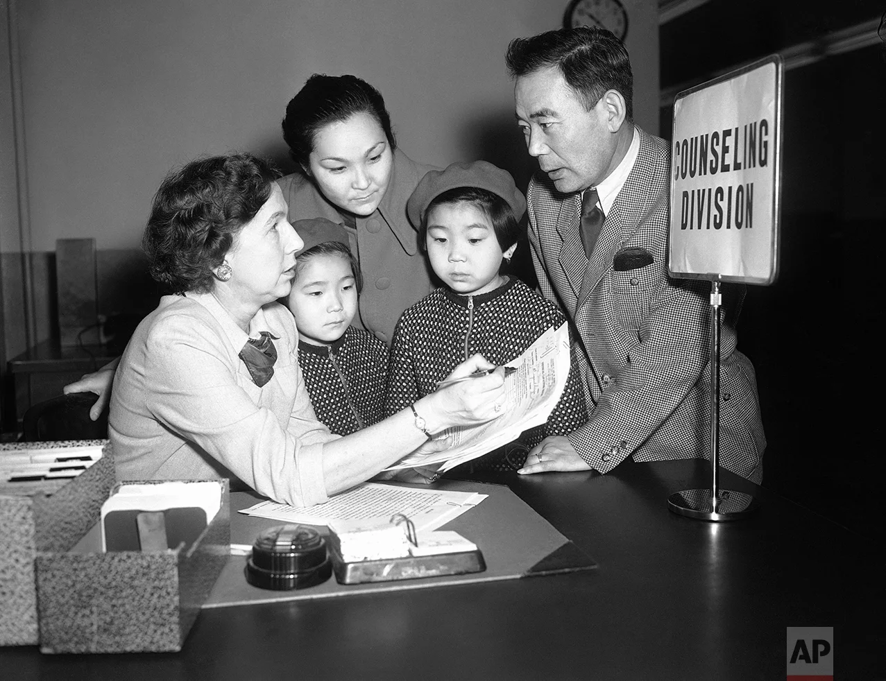 Steps in getting placed in jobs are outlined to Sodman Dalantinow, one of the Kalmuks, of Mongolian origin, coming to this area to live, by State Employment counselor Ruth Griffin, left, while Dalantinow’s wife and two small daughters, Baska, 6, and Zema, 8, listen in Philadelphia on Feb. 5, 1952. Dalantinew is one of 600 Kalmuks, first ever to be brought to the United States. They are coming here from displaced persons camps in Germany as the United States is the only country which would permit their immigration. (AP Photo/WMW)