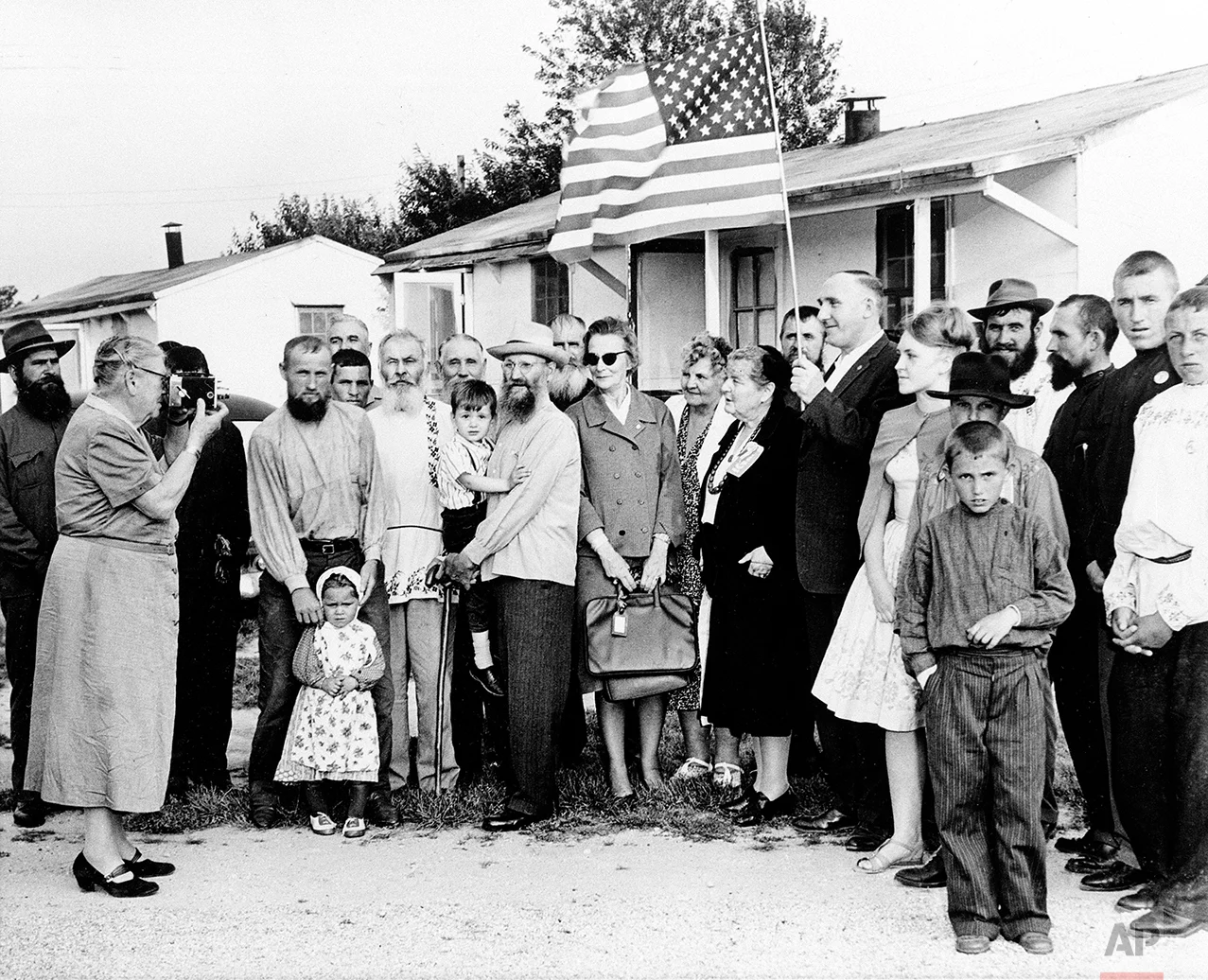A group of 208 Russians, who arrived at a farm from Ankara, Turkey, pose for a picture taken by Countess Alexandra L. Tolstoy, left, president of the Tolstoy Foundation that sponsored their resettlement in Bridgeton, N.J., June 6, 1963. (AP Photo)