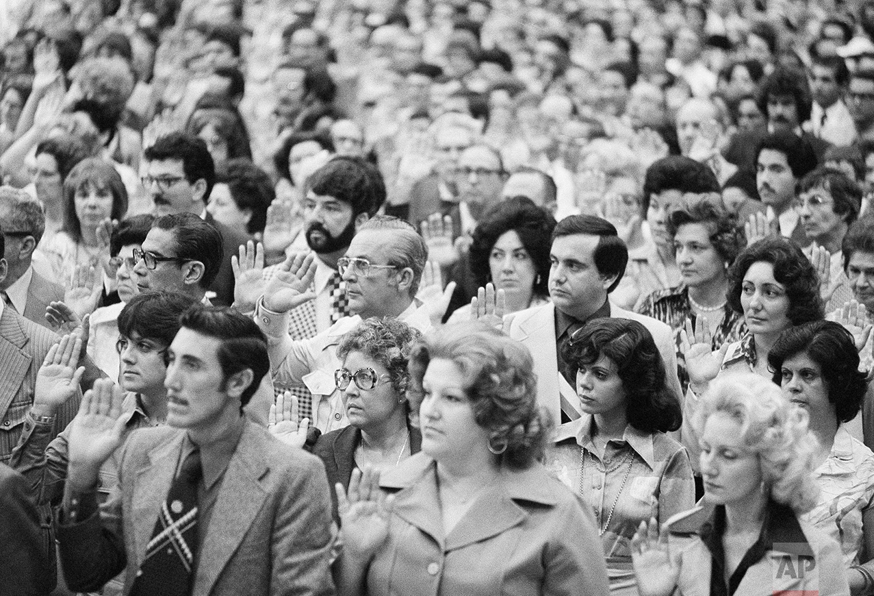 Part of a group 17,1941 persons take the oath of allegiance to the U.S. and become citizens in one of the largest naturalization ceremonies in history, Sunday, July 5, 1976, Miami Beach, Fl. The people in the photograph are unidentified. (AP Photo/BH)