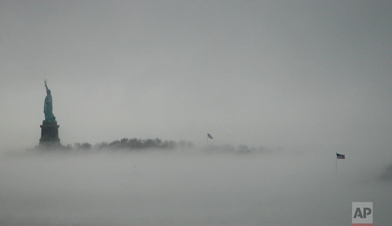 In this Saturday, Jan. 11, 2014 file photo, the Statue of Liberty is surrounded by fog on Liberty Island in New York. The American self-image is forever intertwined with the melting pot - a nation that embraces the world’s wretched refuse, a nation built by immigrants. But America’s immigration history is complicated. (AP Photo/Santiago Lyon)
