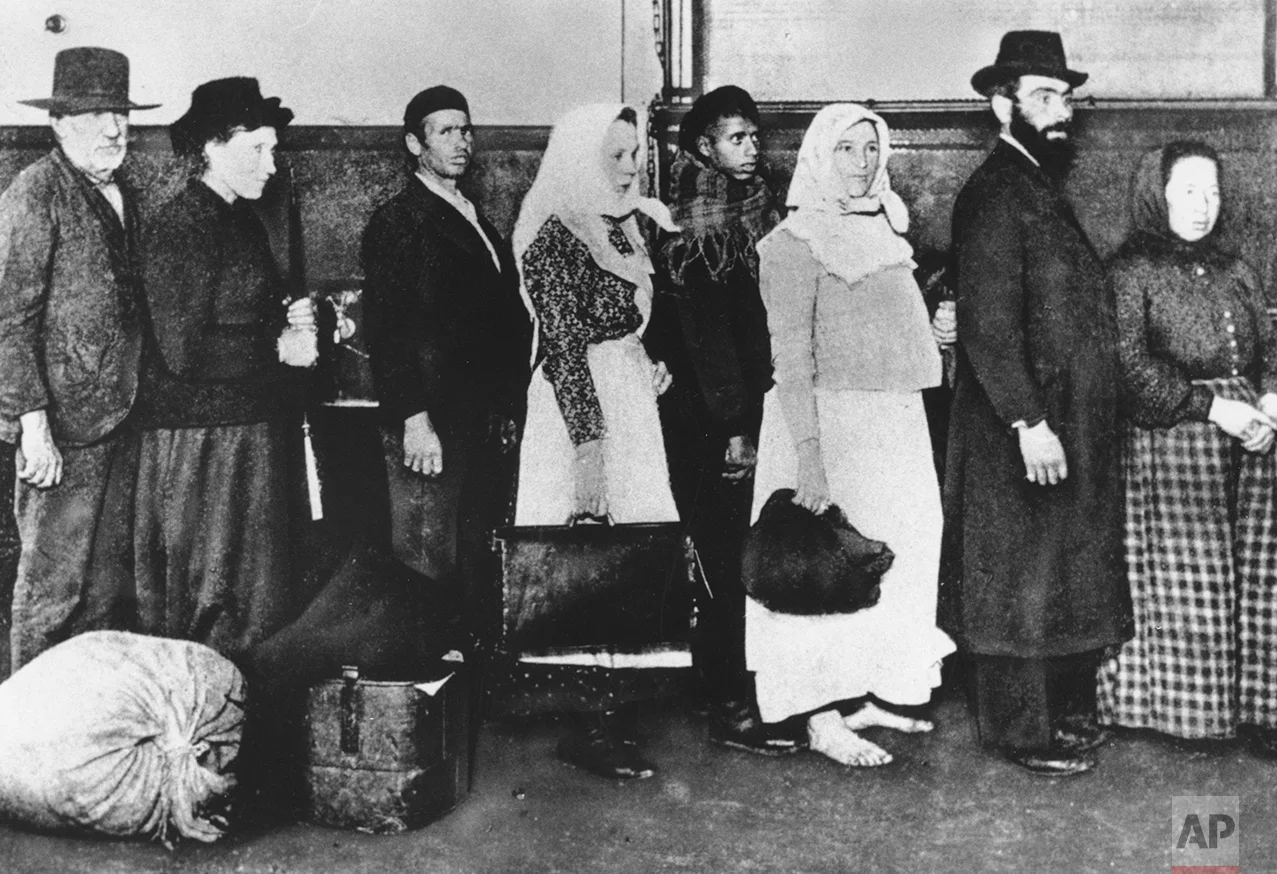 This is an undated photo of a group of immigrants arriving at Ellis Island in New York. They are waiting in line to begin immigration proceedings. (AP Photo)