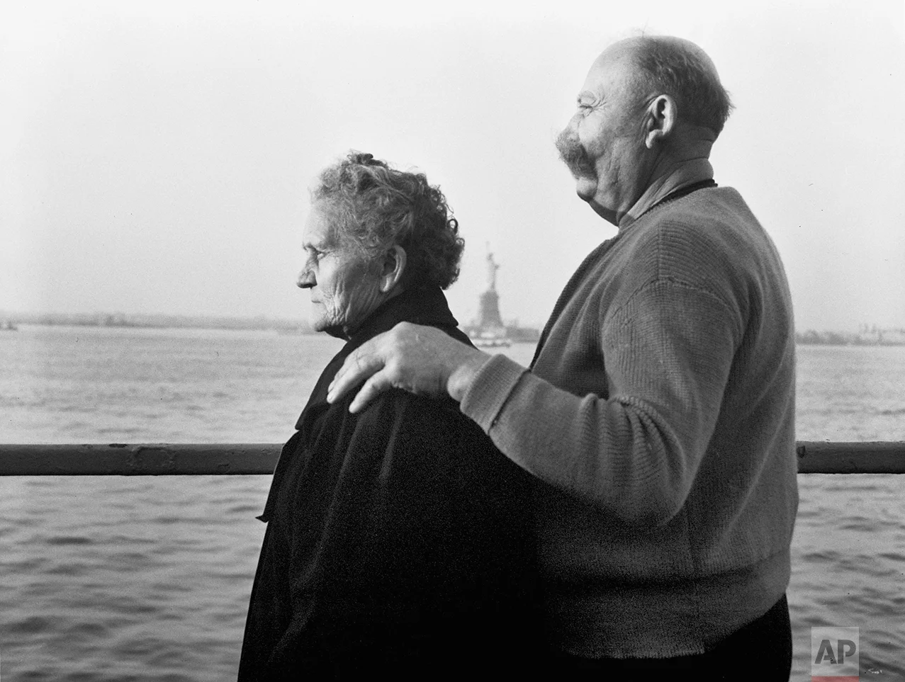 In this Oct. 28, 1956 photo, Mr. and Mrs. Paul Roerich from Bavaria, Germany, look out from the stern of the USNS General Langfitt anchored in New York Harbor carrying 1,267 refugees from Europe. In the background is the Statue of Liberty. The couple plan to settle in Ohio. The American self-image is forever intertwined with the melting pot _ a nation that embraces the world’s wretched refuse, a nation built by immigrants. But America’s immigration history is complicated. (AP Photo)