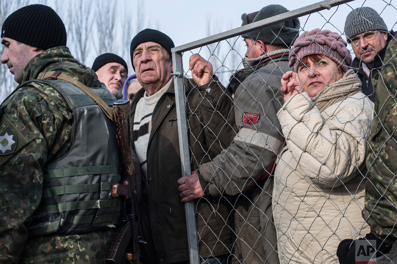 Local residents line up for help at the humanitarian aid center in Avdiivka, eastern Ukraine, Friday, Feb. 3, 2017. Strong shelling hit both government- and rebel-controlled areas of eastern Ukraine in a continued escalation of the country's fighting. (AP Photo/Evgeniy Maloletka)