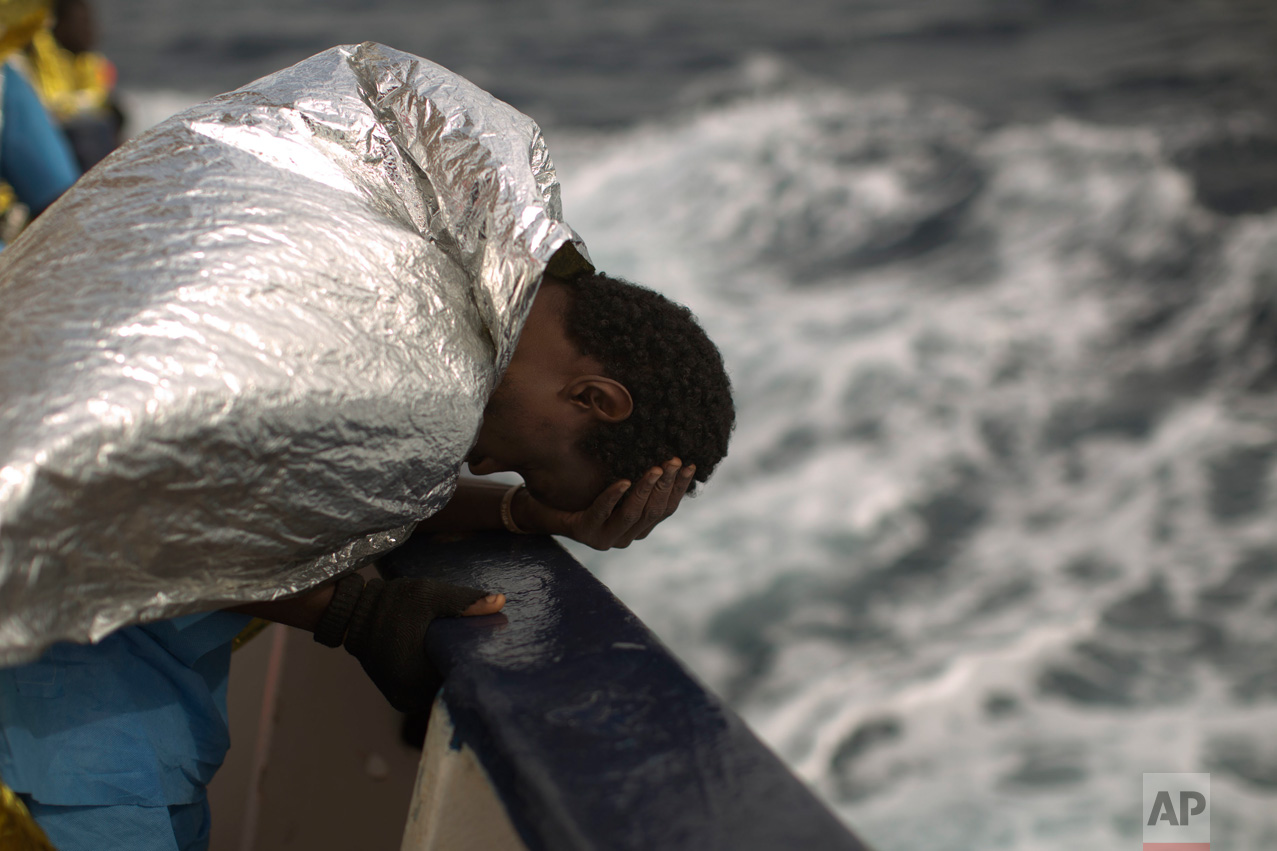 A sub-Saharan migrant holds his head, on the deck of the Golfo Azzurro boat after he was rescued from a rubber boat by members of Proactive Open Arms NGO, on the Mediterranean sea, about 24 miles north of Sabratha, Libya, Saturday, Jan. 28, 2017. (AP Photo/Emilio Morenatti)