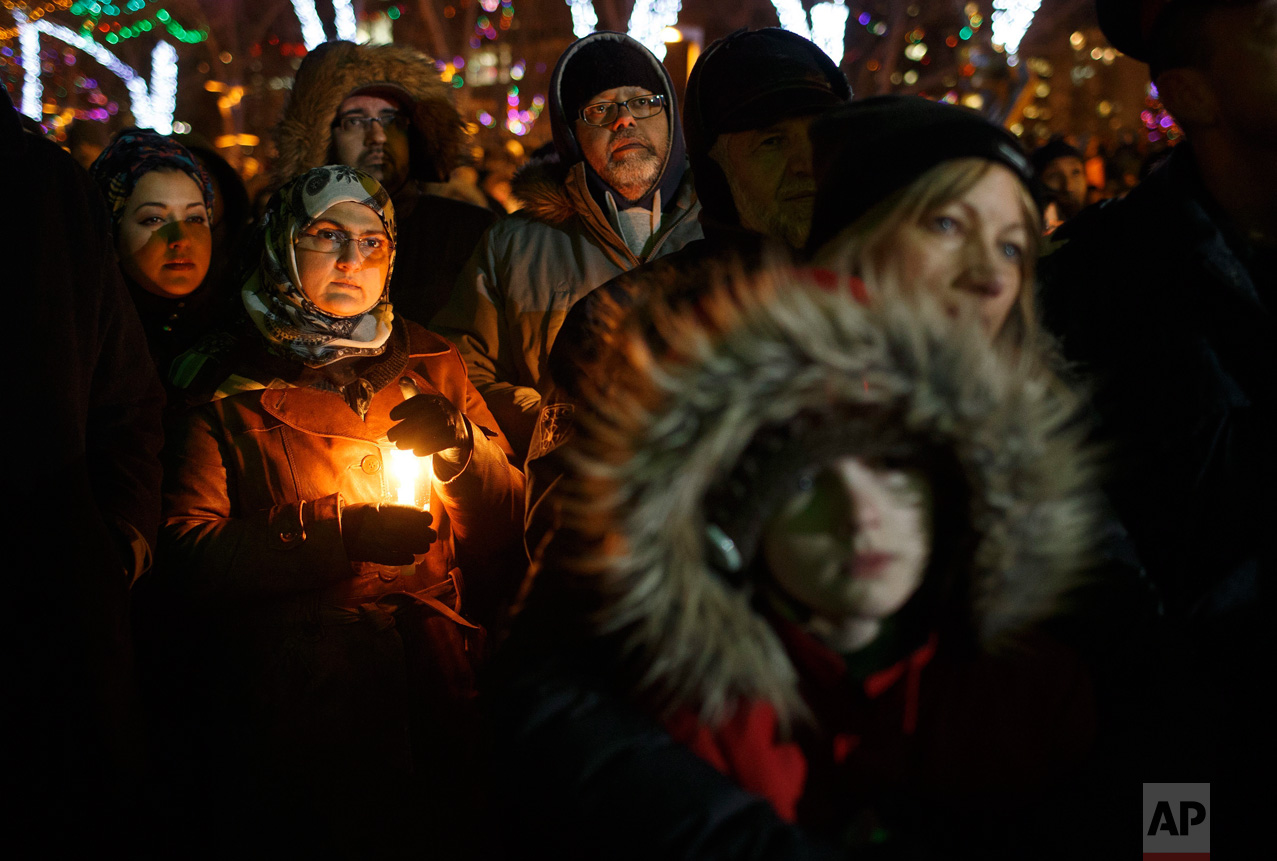 People gather in remembrance of the victims of Sunday's shooting at a Quebec City mosque, during a vigil in Edmonton, Alberta, Monday, Jan. 30, 2017. A French Canadian known for far-right, nationalist views was charged with six counts of first-degree murder and five counts of attempted murder over the shooting rampage at the mosque that Canada's prime minister called an act of terrorism against Muslims. (Jason Franson/The Canadian Press via AP)
