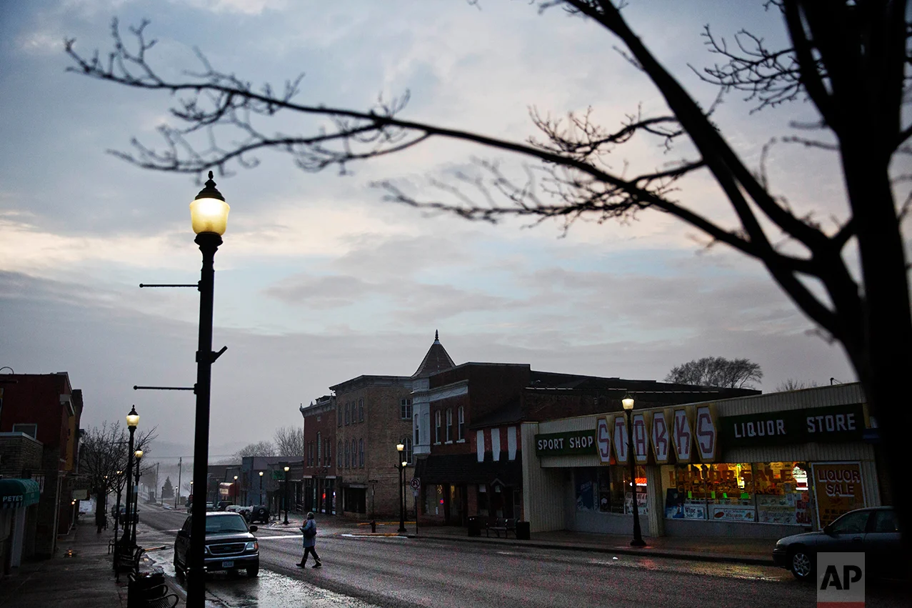 A customer crosses the street while leaving a shop along the main business district in Prairie du Chien, Wis., in Crawford County, Thursday, Jan. 19, 2017. The county is one of dozens in middle America that switched from blue to red in November, but these Trump voters aren't looking for changes on immigration or refugees; if promises of an economic renaissance aren't fulfilled, they warn that Trump could be out four years from now. (AP Photo/David Goldman)