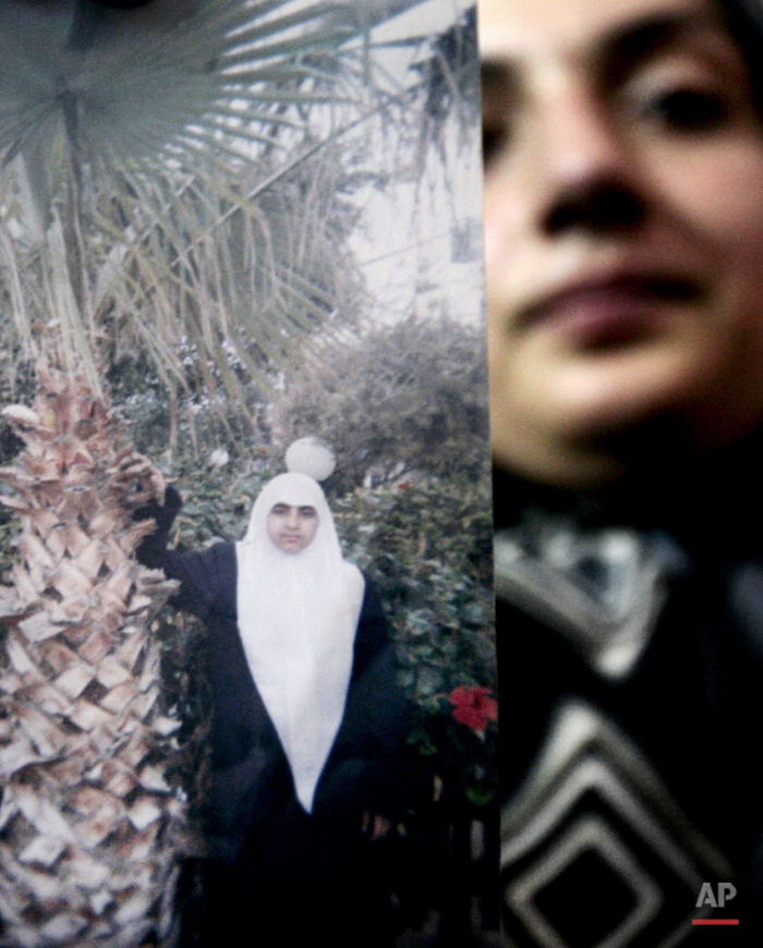  In this Monday Nov. 6, 2006 photo, an unidentified relative holds a photo of Palestinian female suicide bomber Merfat Masoud at the family house in the northern Gaza Strip town of Beit Lahiya. While most suicide bombers are men, Islamic militant gro