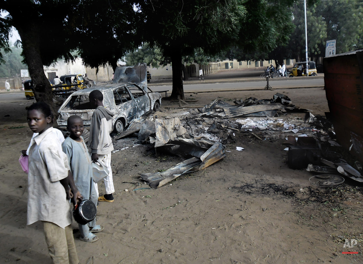  In this Monday Jan. 12, 2015 photo, Children stand near the scene of an explosion a day after two female suicide bombers targeted the busy marketplace in Potiskum, Nigeria. While most suicide bombers are men, Islamic militant groups have occasionall