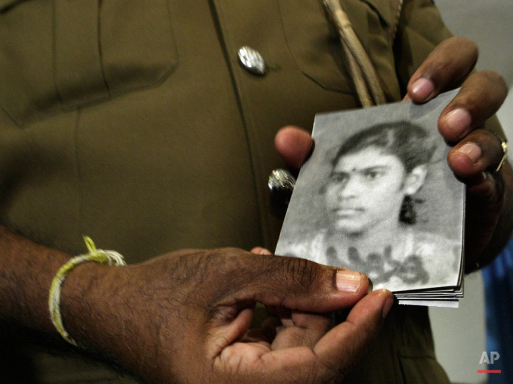  In this Friday, Nov. 30, 2007 photo, a police spokes person distributes photographs of an alleged female suicide bomber who exploded outside a senior minister's office in Colombo, Sri Lanka. While most suicide bombers are men, Islamic militant group
