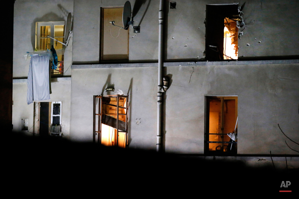  In this Wednesday, Nov. 18, 2015 photo, bullet holes are pictured around a window on the back side of the house after an intervention of security forces against a group of extremists in Saint-Denis, near Paris. A woman wearing an explosive suicide v