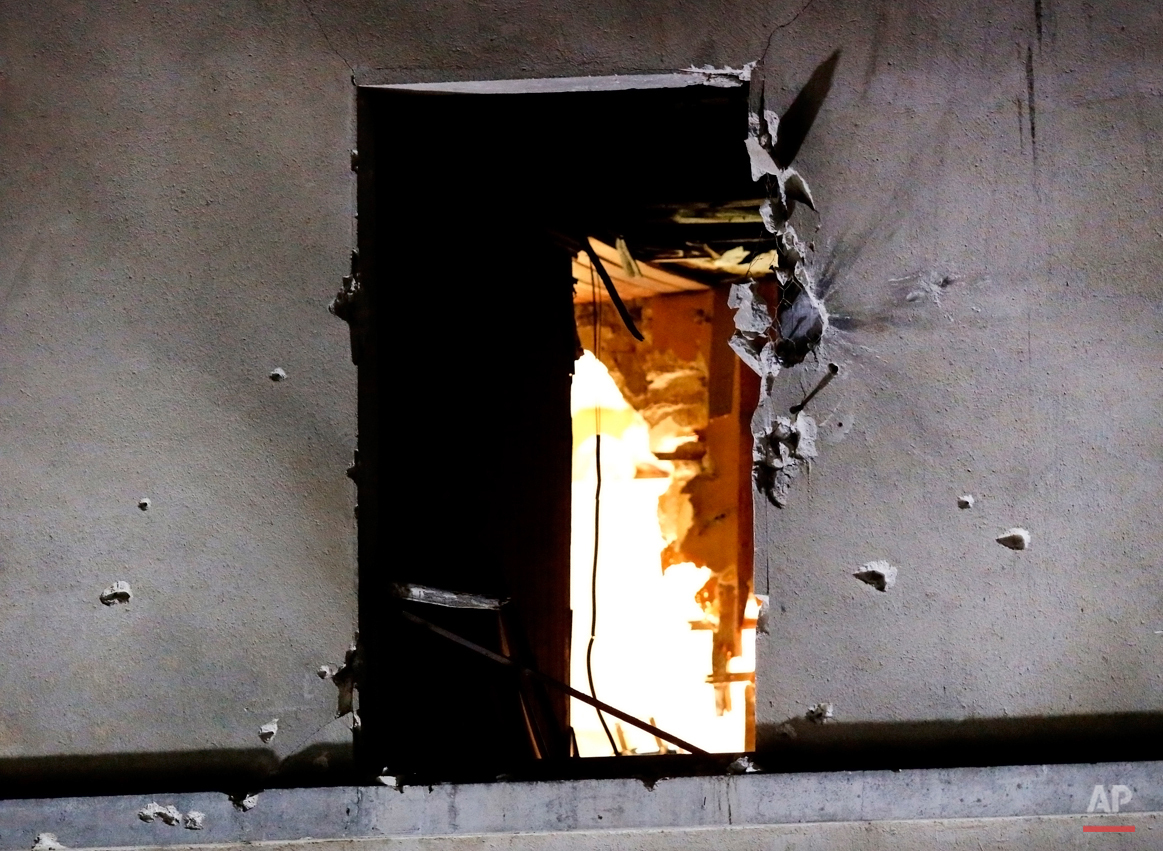  In this Wednesday, Nov. 18, 2015 photo, bullet holes are pictured around a window on the back side of the house after an intervention of security forces against a group of extremists in Saint-Denis, near Paris. A woman wearing an explosive suicide v