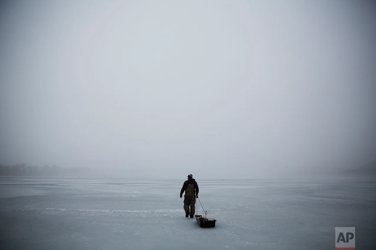 An ice fisherman walks out on a frozen portion of the Mississippi River in Prairie du Chien, Wis., Friday, Jan. 20, 2017. In this corner of middle America, in this one, small slice of the nation that sent Trump to Washington, they are watching and they are waiting, their hopes pinned on his promised economic renaissance. And if four years from now the change he pledged hasn't found them here, the people of Crawford County might change again to someone else. (AP Photo/David Goldman)