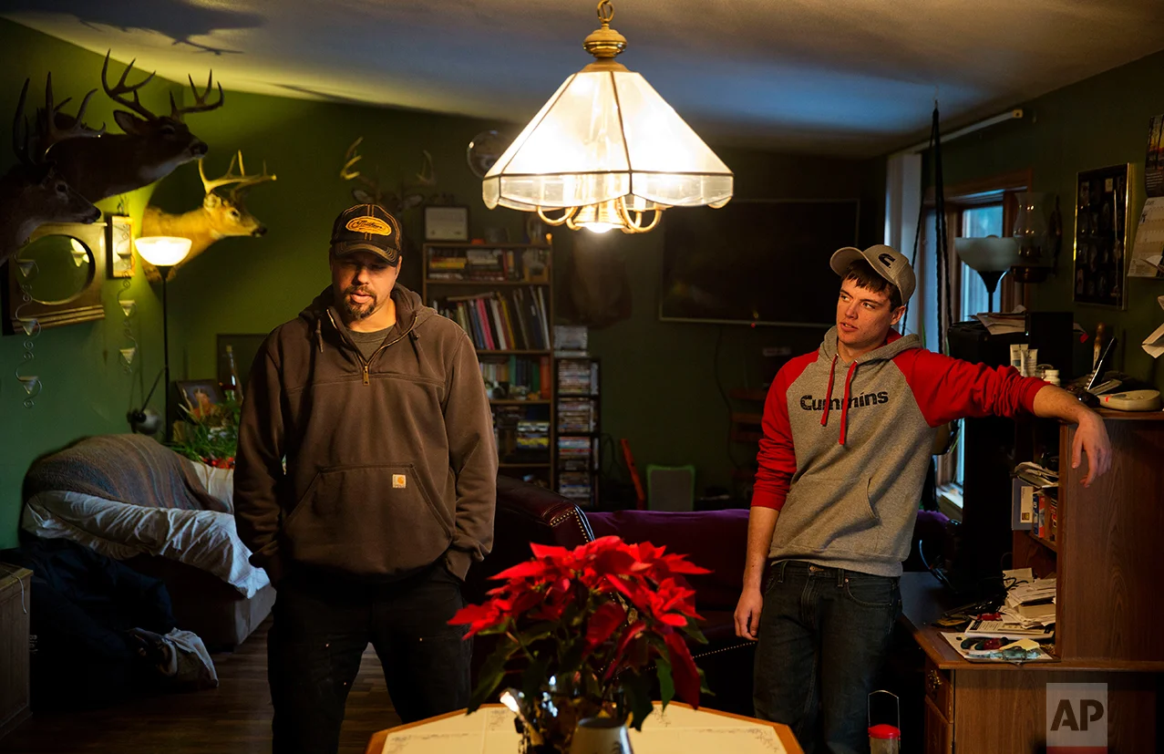 Jeff McCullick, left, stands next to his son Dylan, 18, in their home in Ferryville, Wis., Wednesday, Jan. 18, 2017. Dylan said he supported Barack Obama when he was younger and wanted his parents to vote for the first black president. But he said he's not sure he would vote for Obama as an adult. A recent high school graduate, he said he's worried about the lack of job opportunities in the county and is considering going to technical school to become a diesel mechanic. His father works in maintenance in a federal government job. (AP Photo/David Goldman)
