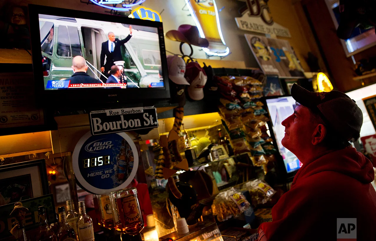Robbo Coleman watches a live broadcast of former President Barack Obama waving goodbye during the inauguration of President Donald Trump at the Sawmill Saloon in Prairie du Chien, Wis., Friday, Jan. 20, 2017. Coleman voted for Obama four years ago. This time, he voted for Trump. To explain why, he held up an ink pen, wrapped in plastic with "Made in China" printed in block letters. "I don't see why we can't make pens in Prairie du Chien, or in Louisville, Ky., or in Alabama, or wherever," he said. (AP Photo/David Goldman)