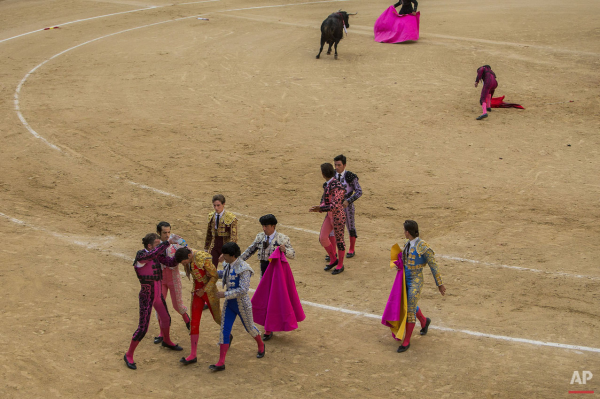  Bullfighter Lilian Ferrani, bottom third left, gets help by his mates after he was  tossed by a fighting bull during a bullfight at Las Ventas bullring in Madrid, Spain, Sunday, June 21, 2015. Bullfighting is a traditional spectacle in Spain and the