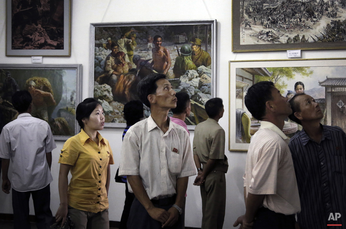  North Koreans look at paintings on display, Sunday, July 26, 2015, in Pyongyang, North Korea. The art exhibition comprised of works by different local artists on the life of North Koreans during the Japanese occupation and before their country's lib