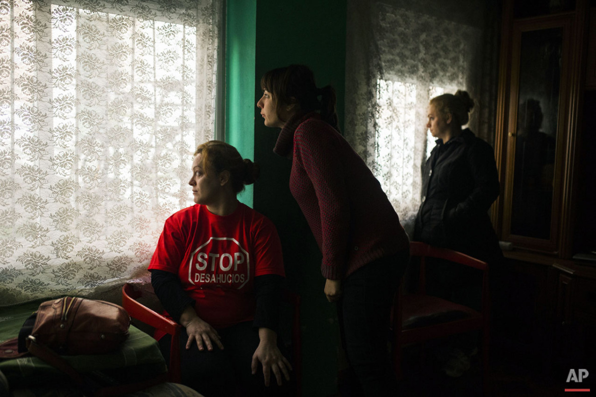  Rosario Echevarria Pedrezuela, left, her sister, right, and a housing right activist, centre, look at the police cordon the area around the apartment to evict her in Madrid, Spain, Monday, Feb. 16, 2015. The apartment occupied by Echevarria Pedrezue
