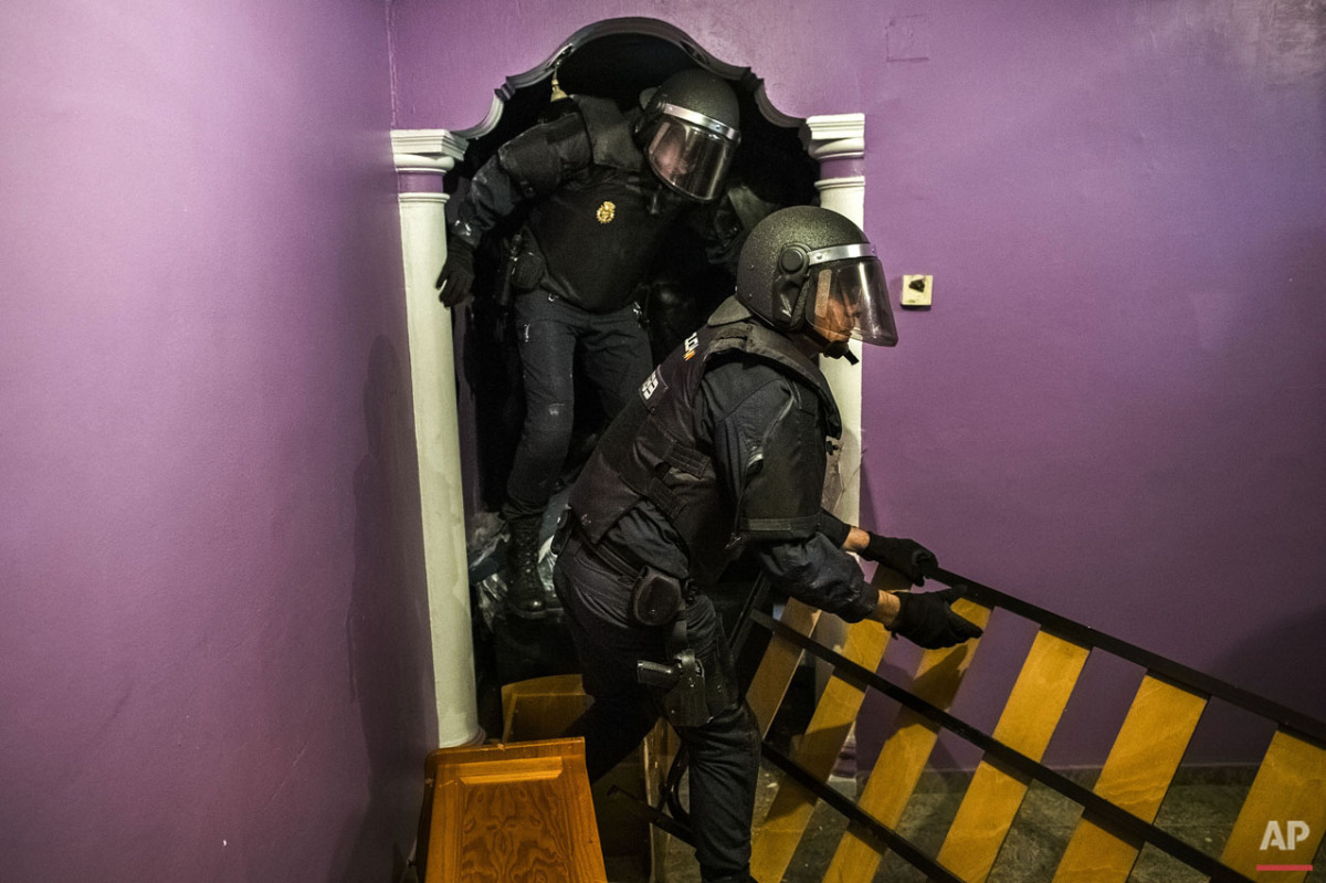  Police enter the apartment of Emilia Montoya Vazquez by forcing their way in between furniture after they broke down the main door to evict her and her family in Madrid, Spain, Wednesday, Feb. 25, 2015. Montoya, who lived with her son and daughter i