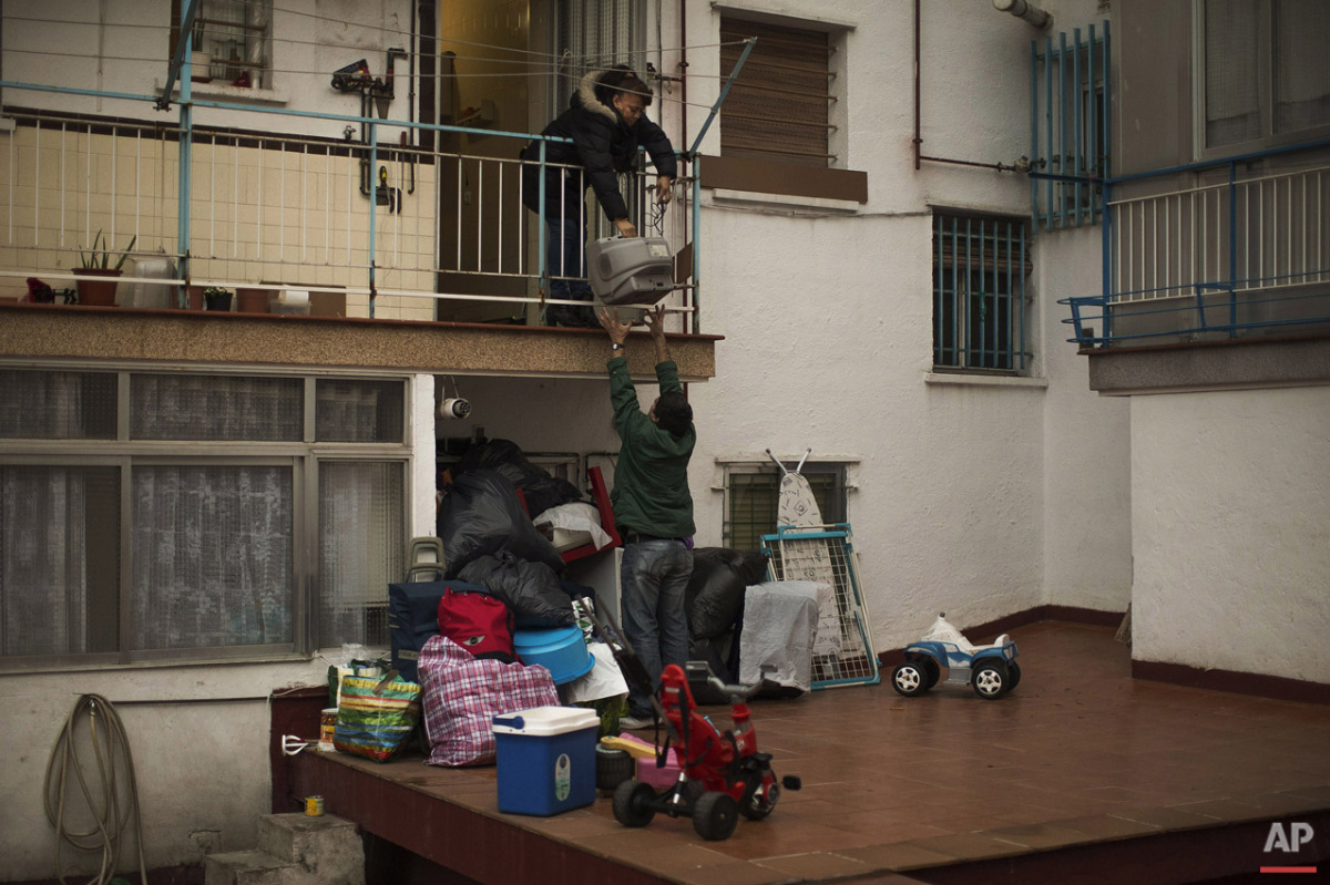  Mercedes Pincay, 50 years, empties her apartment through the back door as riot police surround them to evict her and her partner in Madrid, Spain, Monday, Dec. 15, 2014. The landlord's loss of the apartment to a Bankia bank caused Mercedes Pincay an