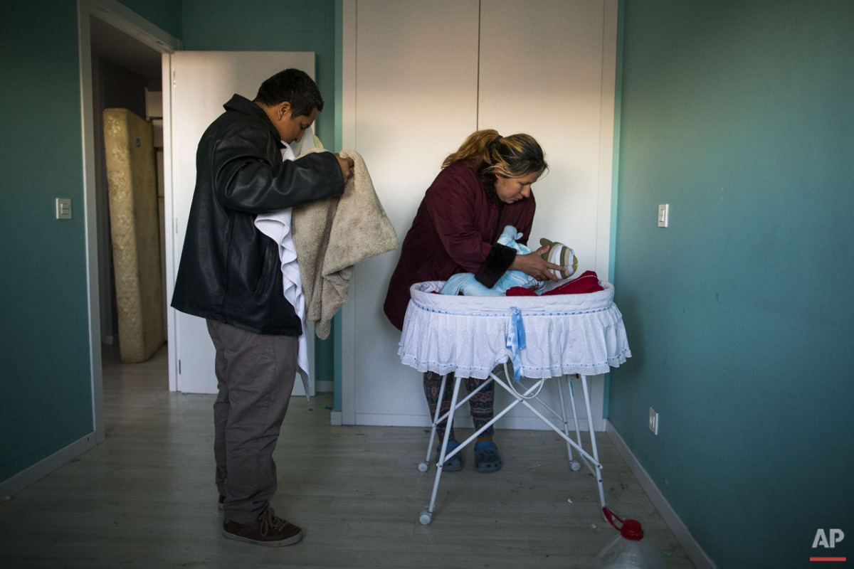  Furniture are packed behind the main door to stop riot police to enter the apartment as Cecilia Paredes and her husband Wilson Ruilova prepares to leave with their baby Dilan during their eviction in Madrid, Spain, Friday, Jan. 23, 2015. Paredes, 43