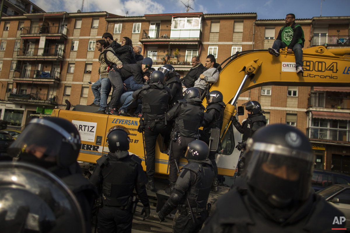  Riot Police remove a housing rights activists who claimed a bulldozer as they triy to stop Luisa Gracia Gonzalez and her family's eviction and the demolition of their house by a forced expropriation in Madrid, Spain, Friday, Feb. 27, 2015. Madrid au