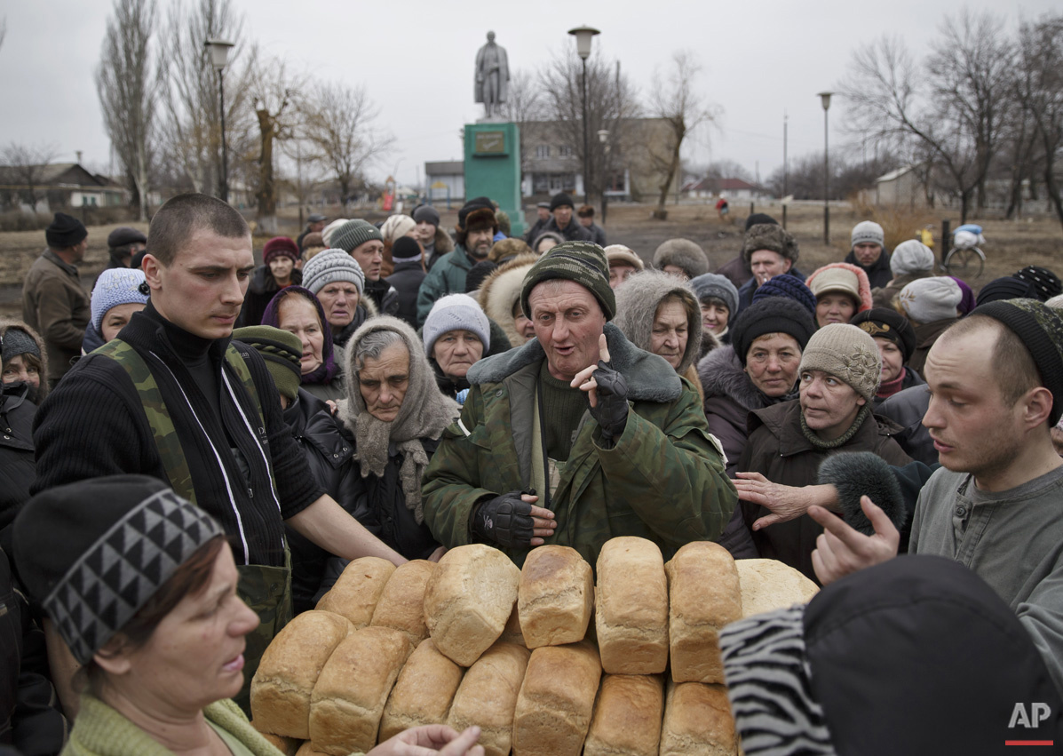  A man speaks to a crowd of residents warning them not to push as they wait to get bread, one per person, baked by Russia-backed separatists in Chornukhyne, Ukraine, Monday, March 2, 2015. More than 6,000 people have died in eastern Ukraine since the
