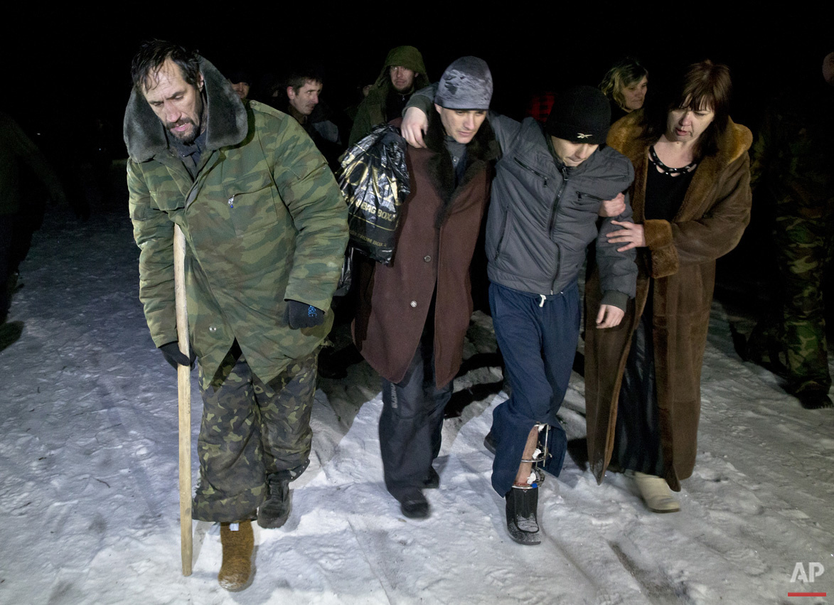  Russia-backed separatists, some injured,  walk on a snowy road in no man's land after being released by the Ukrainian military in a prisoner exchange, near Zholobok,  Ukraine, Saturday, Feb. 21, 2015. Ukrainian military and separatist representative