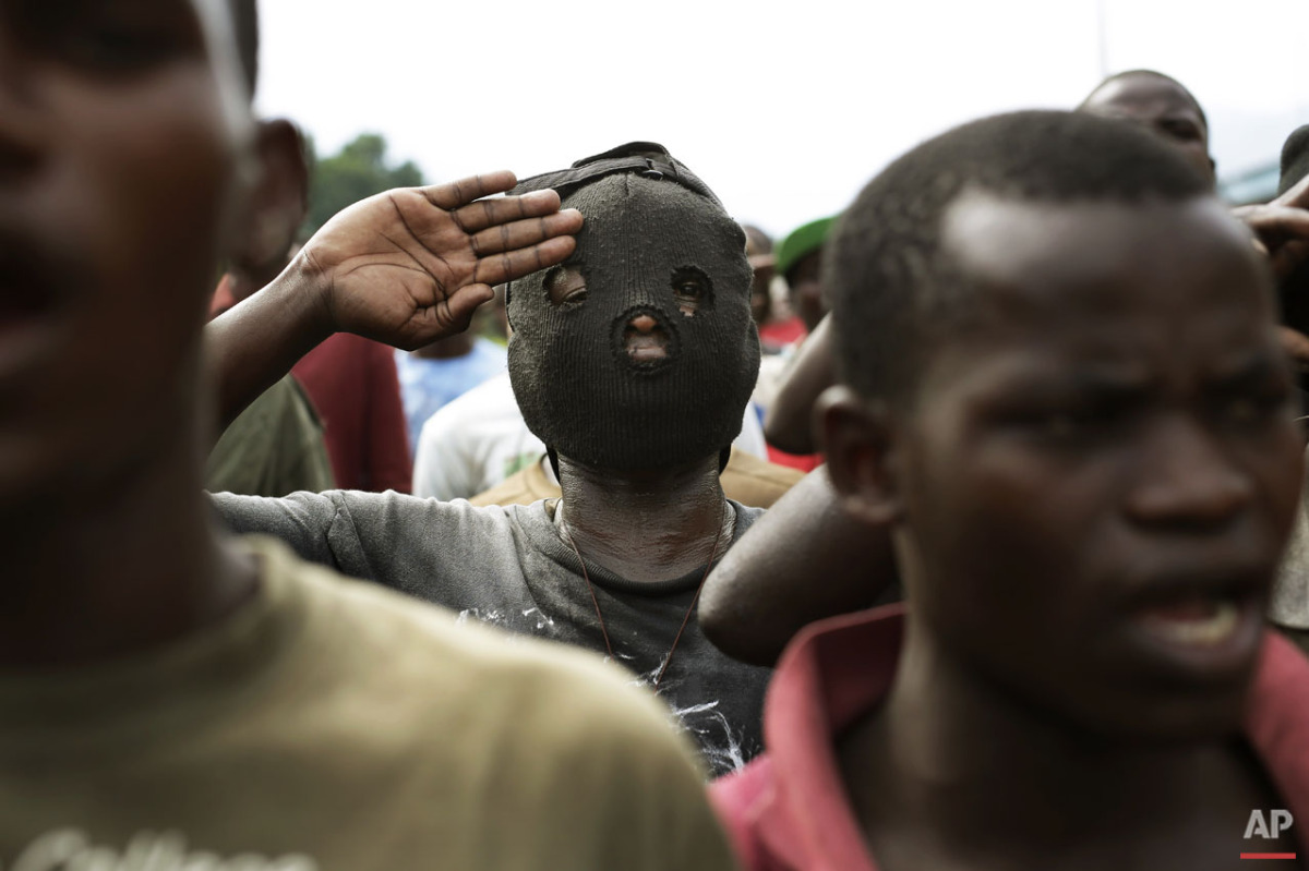  Demonstrators sing the national anthem in front of a line of riot police in the Musaga neighborhood of Bujumbura, Burundi, Friday May 1, 2015. (AP Photo/Jerome Delay) 
