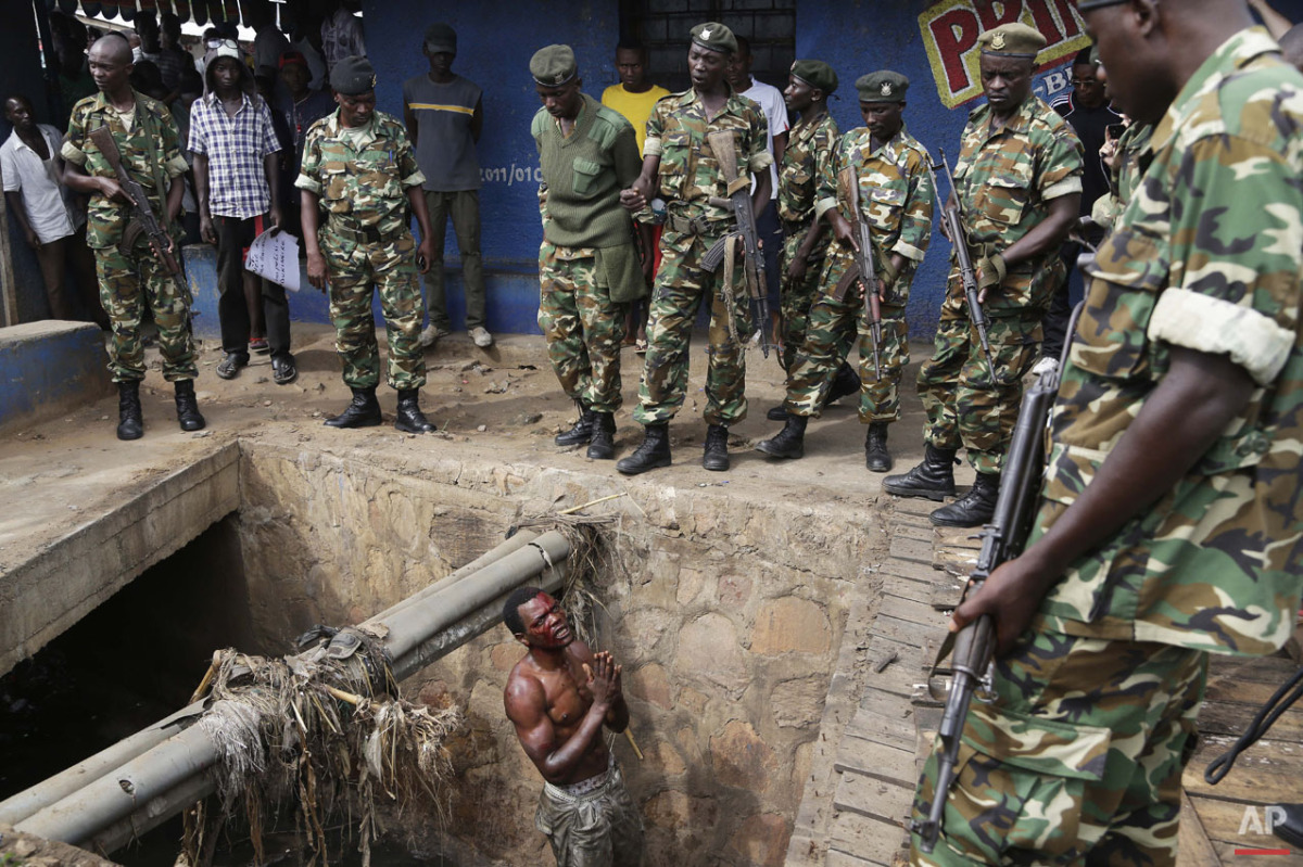  Jean Claude Niyonzima, a suspected member of the ruling party's Imbonerakure youth militia, pleads with soldiers to protect him from a mob of demonstrators after he came out of hiding in a sewer in the Cibitoke  district of Bujumbura, Burundi, Thurs