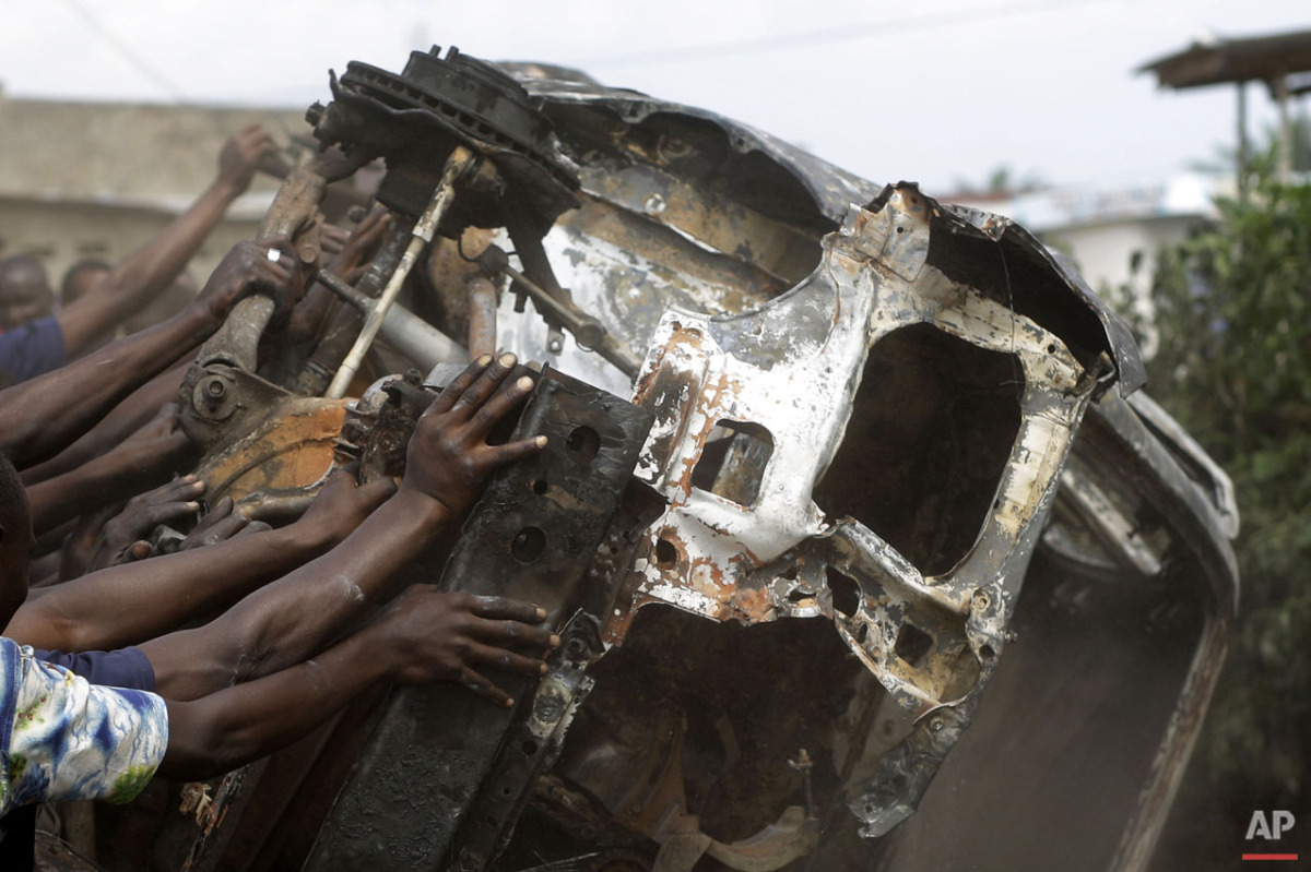  Demonstrators topple a burnt out car in the Musaga neighborhood of Bujumbura, Burundi, Friday May 1, 2015. (AP Photo/Jerome Delay) 