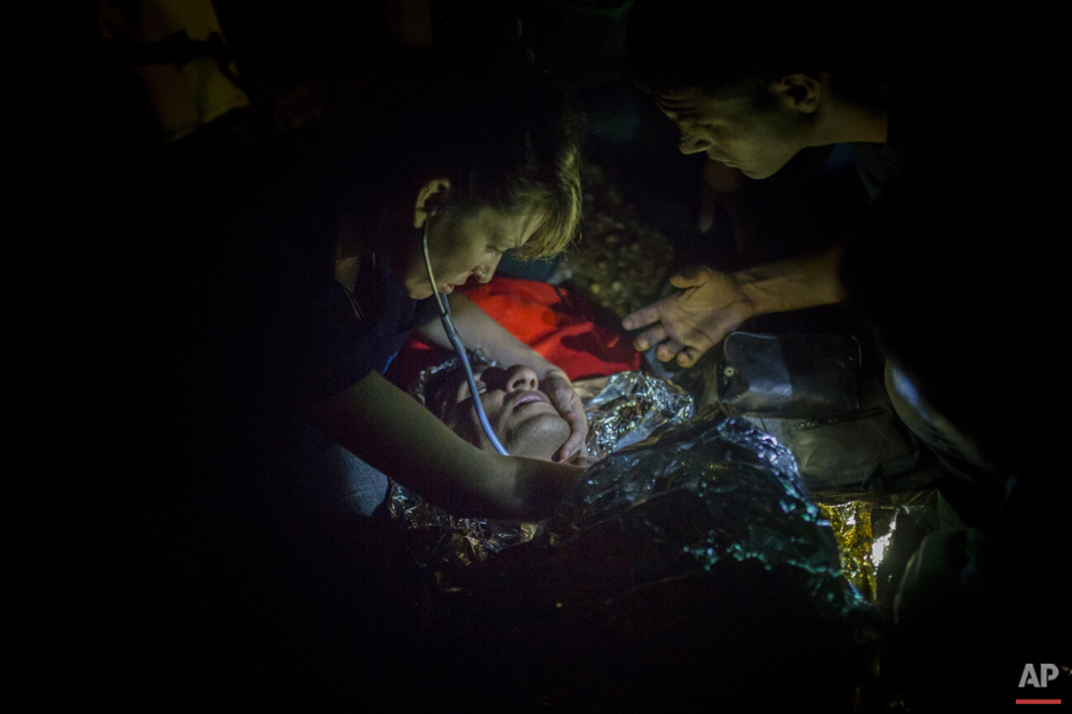  Volunteers provide first aid to a refugee suffering from hypothermia immediately after his arrival on a dinghy from the Turkish coast to the northeastern Greek island of Lesbos, Thursday, Oct. 8, 2015. (AP Photo/Santi Palacios) 