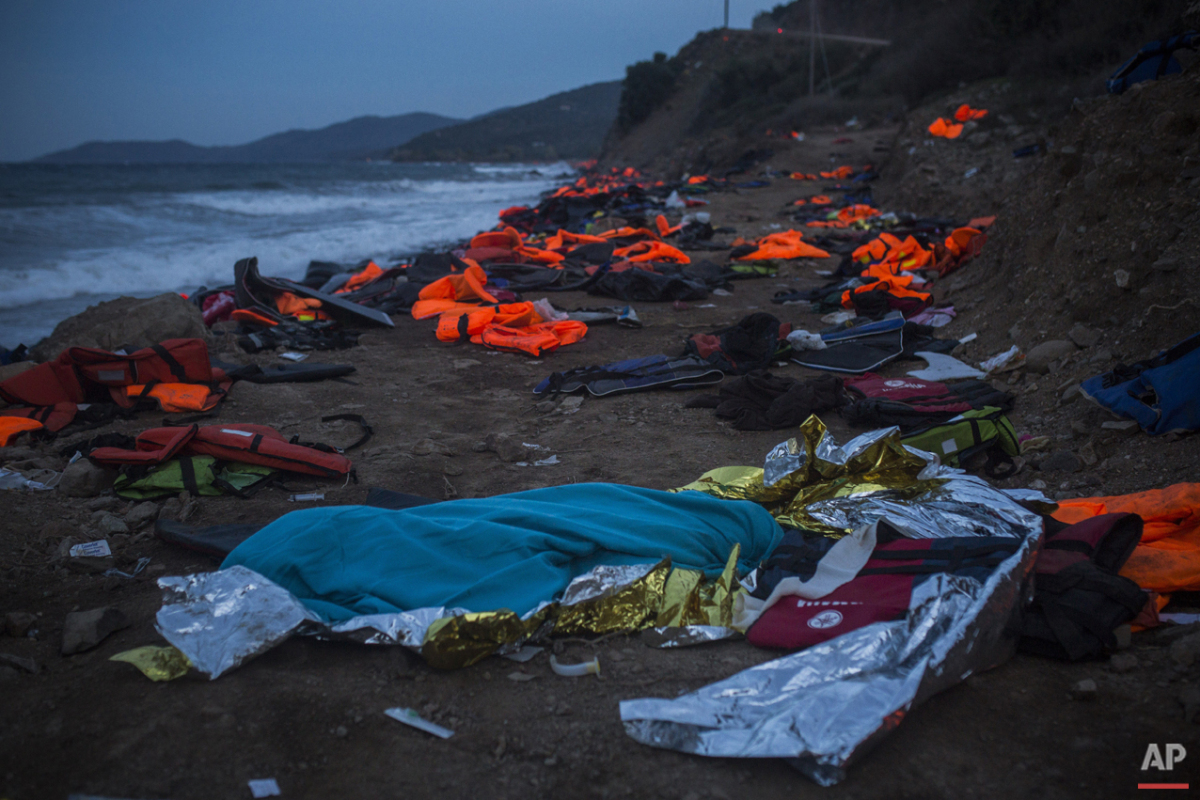  The body of a young man covered with a blue blanket remains on Eftalou beach after his dinghy capsized on the northeastern Greek island of Lesbos, Friday, Oct. 30, 2015. (AP Photo/Santi Palacios) 