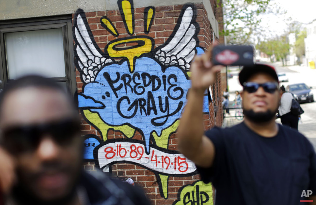  J.R. White, right, takes a selfie in front of a mural that was painted at the site of Freddie Gray's arrest, Saturday, May 2, 2015, in Baltimore, as protesters prepare to march to City Hall. (AP Photo/Patrick Semansky) 