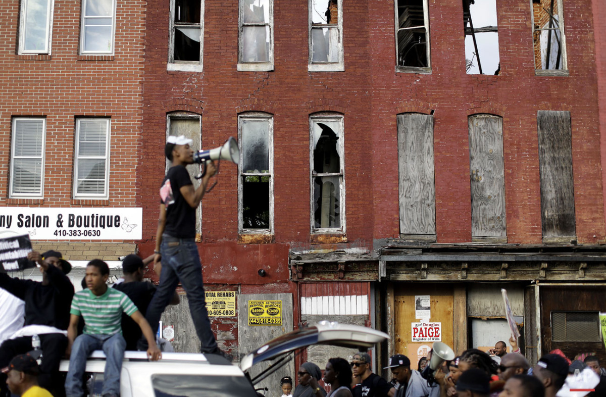  Blighted buildings stand behind a protester as he leads marchers in a chant from atop a vehicle, Saturday, May 2, 2015, in Baltimore. (AP Photo/Patrick Semansky) 