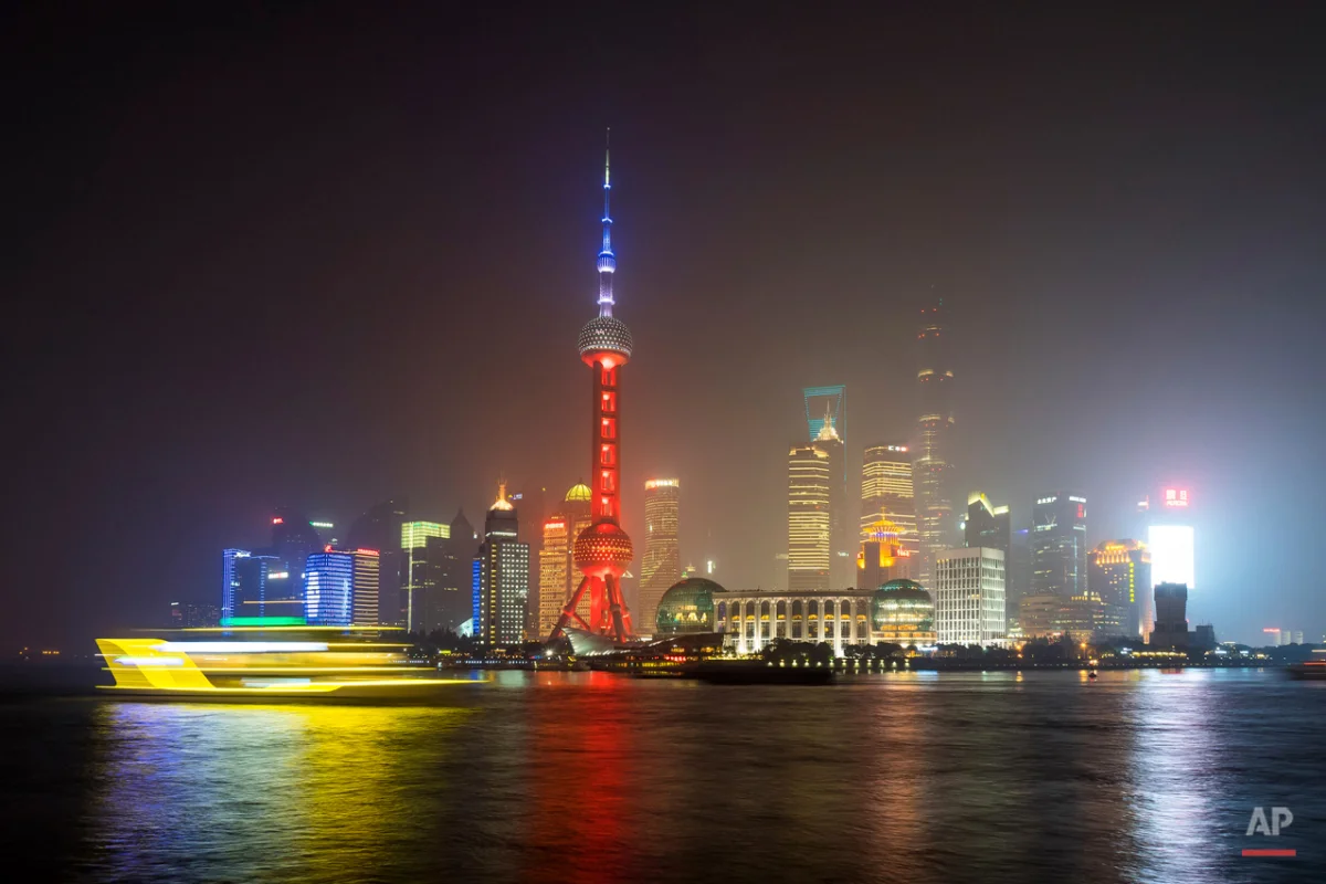 A ferry travels past the Oriental Pearl Tower, lit in the colors of the French flag in Shanghai, China, Saturday, Nov. 14, 2015, following the attacks in Paris on Friday. Multiple attacks across Paris on Friday night have left scores dead and hundreds injured.. (Chinatopix Via AP) CHINA OUT