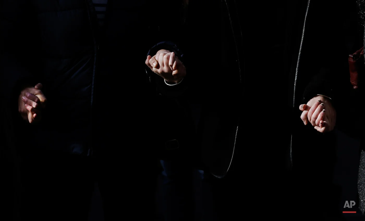 People hold hands as they observe a minute of silence in Lyon, central, Monday, Nov. 16, 2015, three days after the Paris attacks. A minute of silence was observed throughout the country in memory of the victims of the country's deadliest violence since World War II. (AP Photo/Laurent Cipriani)