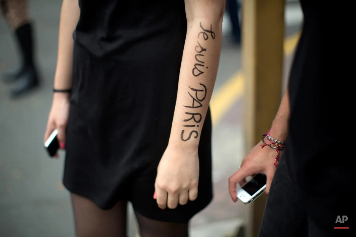 A woman with her arm painted with the phrase in French "I am Paris" participates in a ceremony in Lima, Peru, in homage to the victims of the deadly attacks in Paris, Sunday, Nov. 15, 2015. Multiple terrorist attacks across Paris on Friday night left more than one hundred dead and many more injured. (AP Photo/Rodrigo Abd)