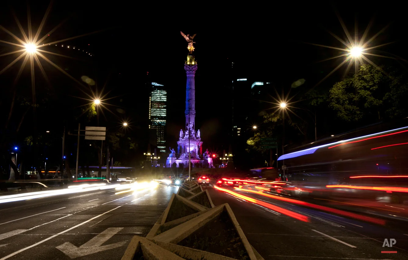 The iconic Angel of Independence monument is lit in the colors of the French flag in Mexico City, Saturday, Nov. 14, 2015, in memory of the victims of attacks in Paris. French President Francois Hollande said Saturday at least 127 people died Friday night when attackers launched gun attacks at Paris cafes, detonated suicide bombs near France's national stadium and killed hostages inside a concert hall during a rock show. More than 200 people were hurt, dozens critically. (AP Photo/Marco Ugarte)