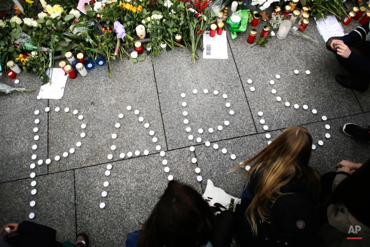 Young women have formed the word Paris with candles to mourn for the victims killed in Friday's attacks in Paris, France, in front of the French Embassy in Berlin, Saturday, Nov. 14, 2015. Multiple attacks across Paris on Friday night have left scores dead and hundreds injured.(AP Photo/Markus Schreiber)