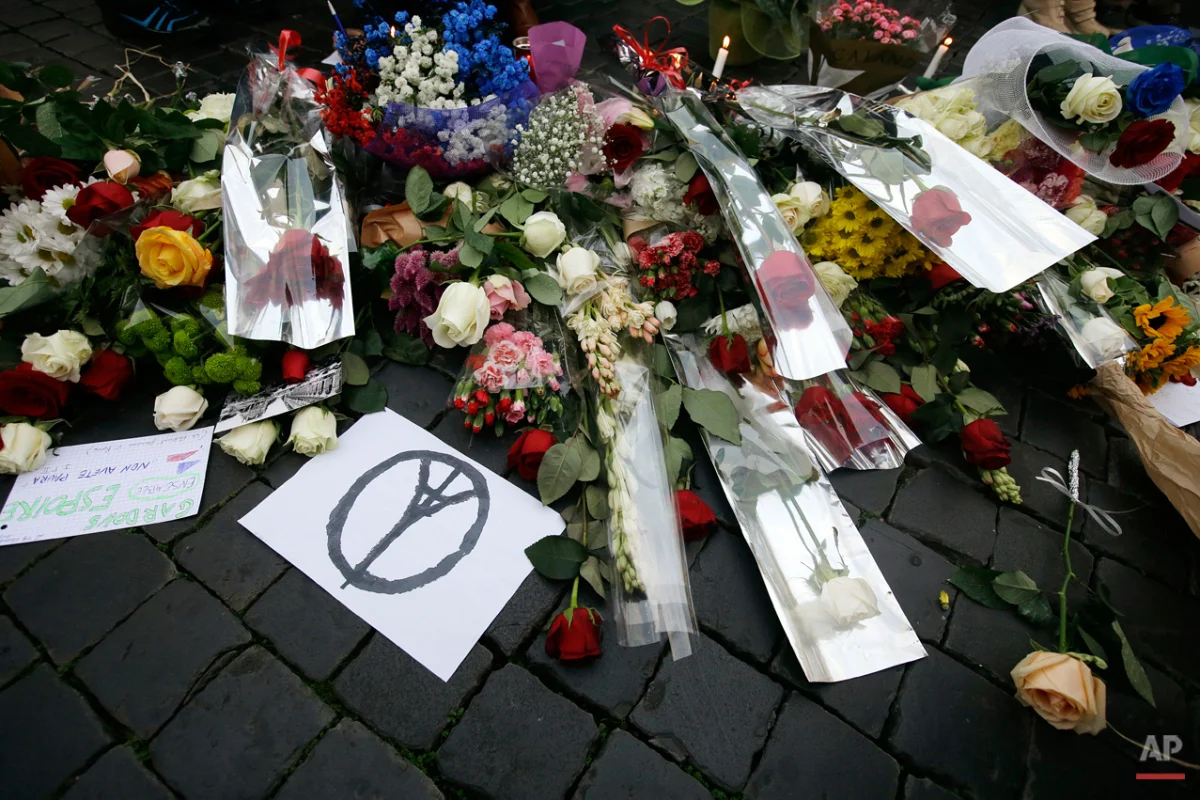 Flowers are laid outside the French embassy in Rome, Saturday, Nov. 14, 2015. French police on Saturday hunted possible accomplices of eight assailants who terrorized Paris concert-goers, cafe diners and soccer fans with a coordinated string of suicide bombings and shootings in France's deadliest peacetime attacks. (AP Photo/Gregorio Borgia)