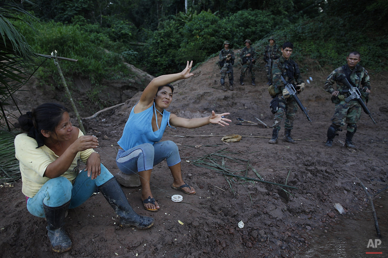  In this July 31, 2015 photo, women fish in the Palcazu River while counternarcotics special forces police wait for their comrades after destroying an airstrip in the Peruvian jungle, used by drug traffickers near Ciudad Constitucion, Peru. The polic